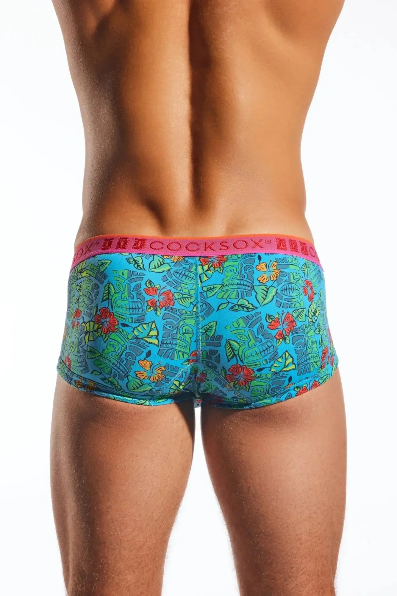 Bright turquoise tropical-patterned men’s briefs with a pink waistband featuring the cocksox brand name