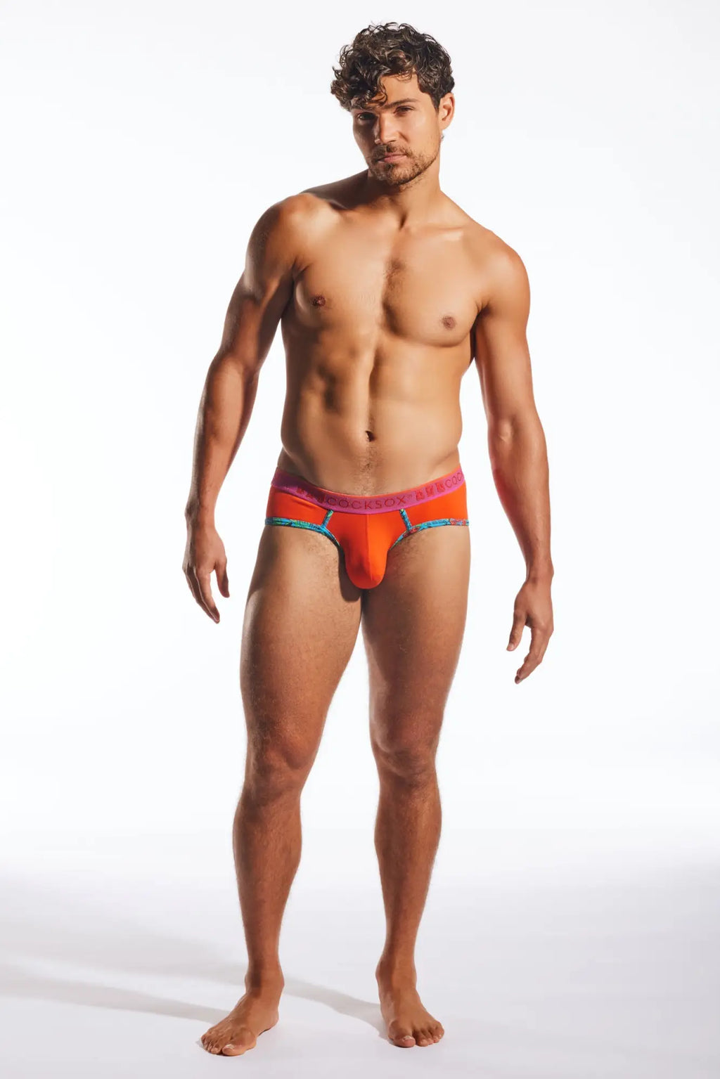 Vibrant orange and pink Cocksox CX76N sports briefs with a colorful elastic waistband designed for men