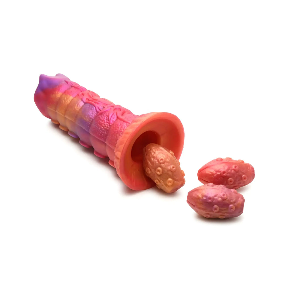 Creature cocks nymphoid ovipositor silicone dildo in vibrant iridescent pink and orange with textured caterpillar shape and hollow end