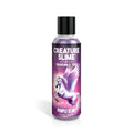 A clear plastic bottle with black cap contains purple creature slime water based lubricant by Creature Cocks