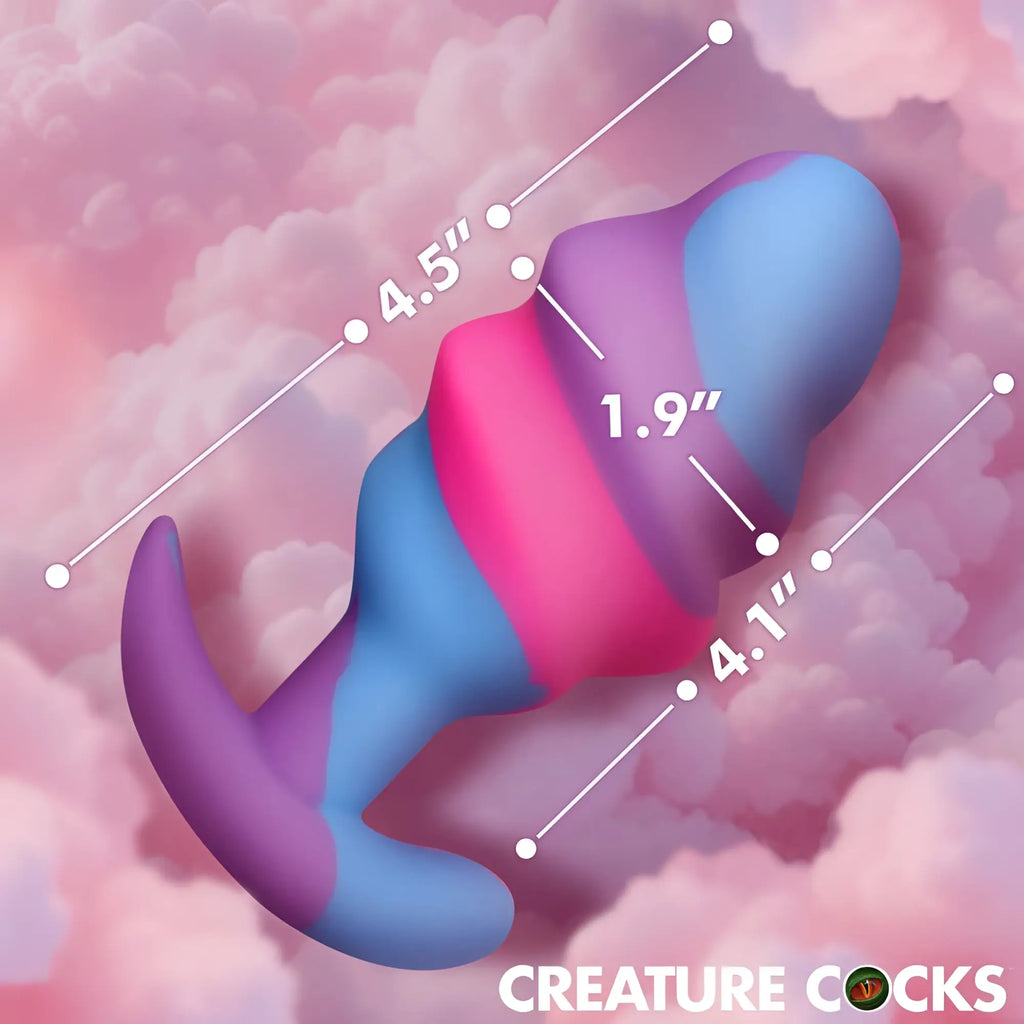 A vibrant rainbow-colored silicone Creature Cocks unicorn swirl large anal plug with curved tail and segmented design