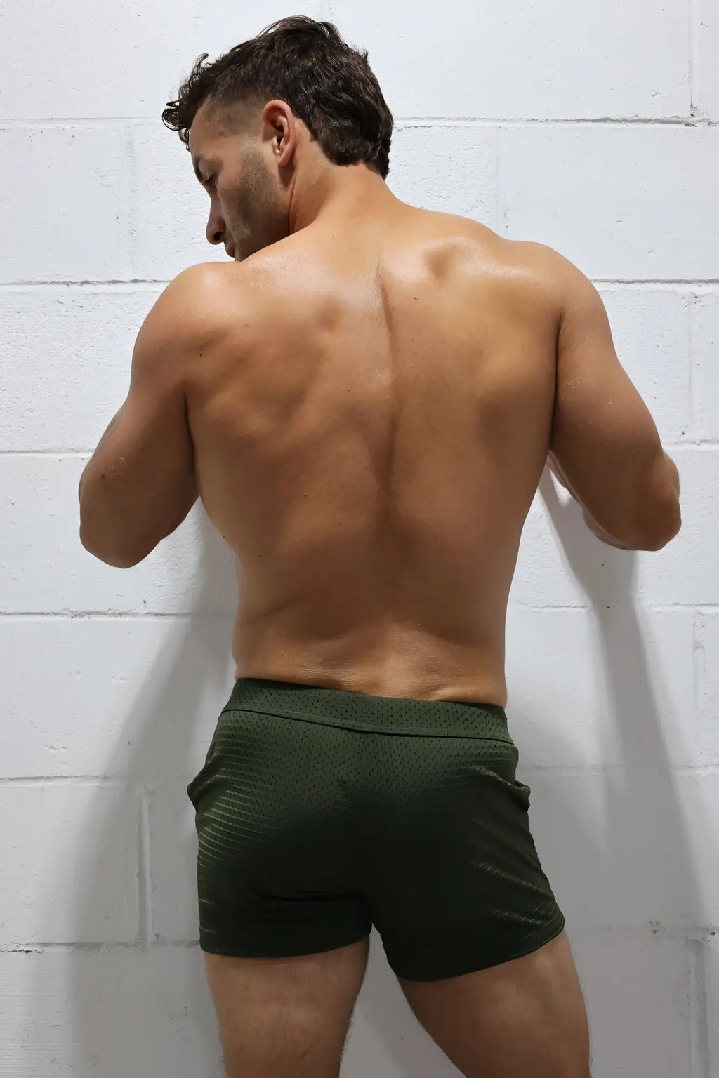 Dark green textured cruiser shorts made of breathable fabric designed for athletic use