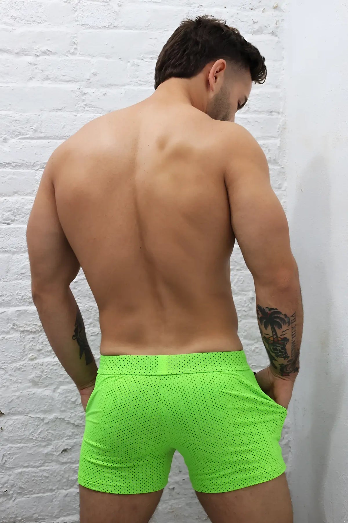 Neon green cruiser shorts made of perforated mesh fabric offering breathable comfort for active wear