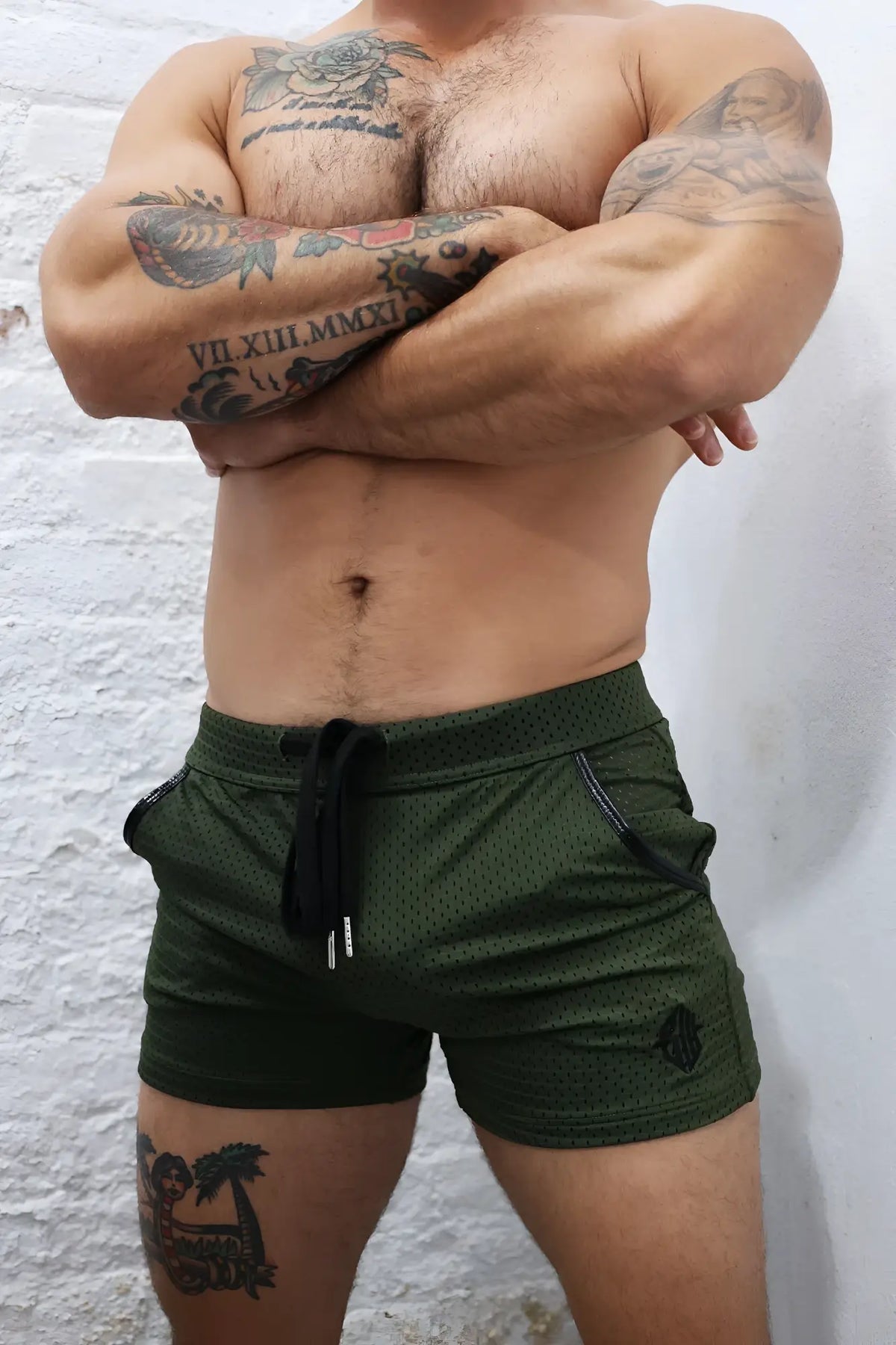 Olive green cruiser shorts made of mesh fabric with black drawstring and side pockets for athletic use