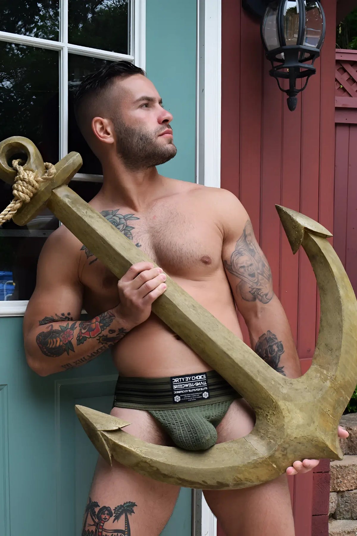 Gold-colored wooden anchor with rope tied around top loop in cumdump jock army green product display
