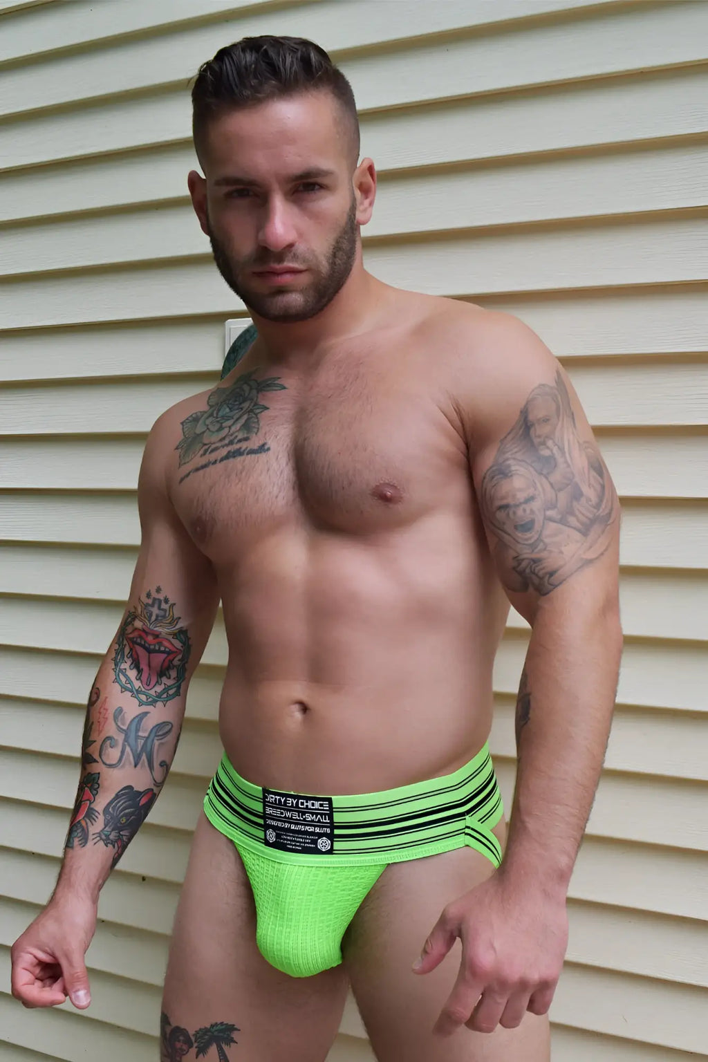Bright neon green athletic briefs cumdump jock with black horizontal stripes and branded waistband label
