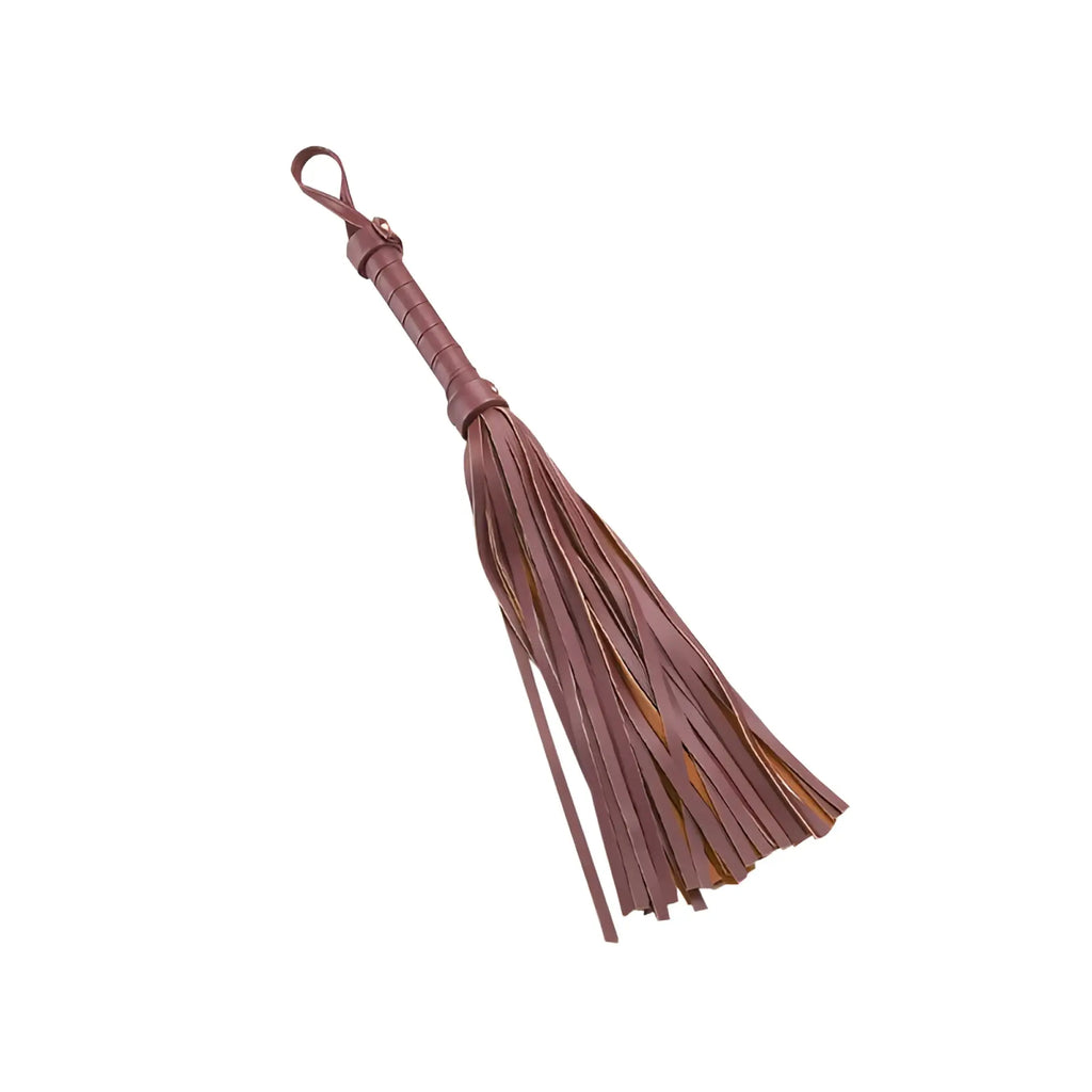 A taupe leather whip with a braided handle and fringed tassel from the daytona 8 pc deluxe bondage play kit burgundy gold