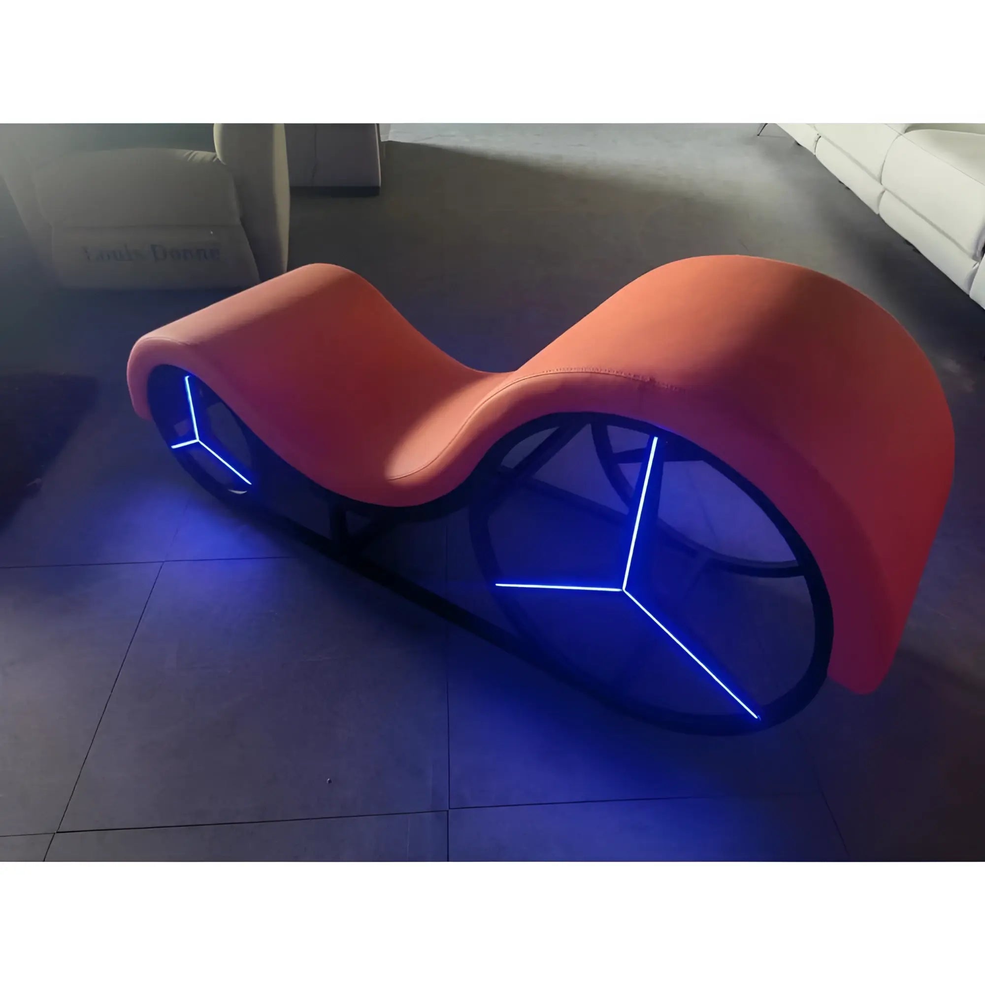 Vibrant orange Daytona Kama Sutra Mebon chaise love lounge with metal frame and blue LED lights along curved design