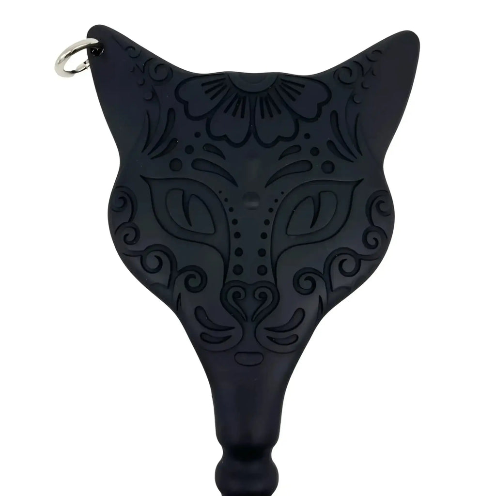 Black cat-shaped demon kat paddle dildo keychain with intricate floral and swirl patterns etched on black surface