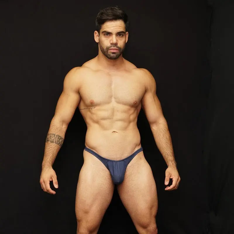 Model wearing dark blue thong underwear made of denim fabric by Arroyman showcasing a fitted design and minimal coverage.