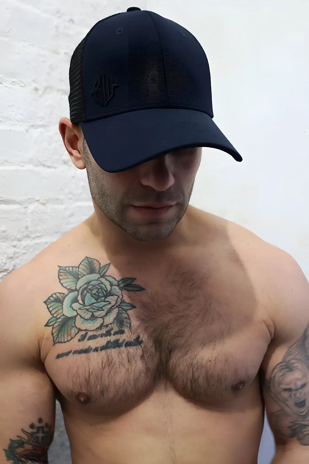 Black trucker-style baseball cap with mesh back and embroidered dirty trucker hat logo on front