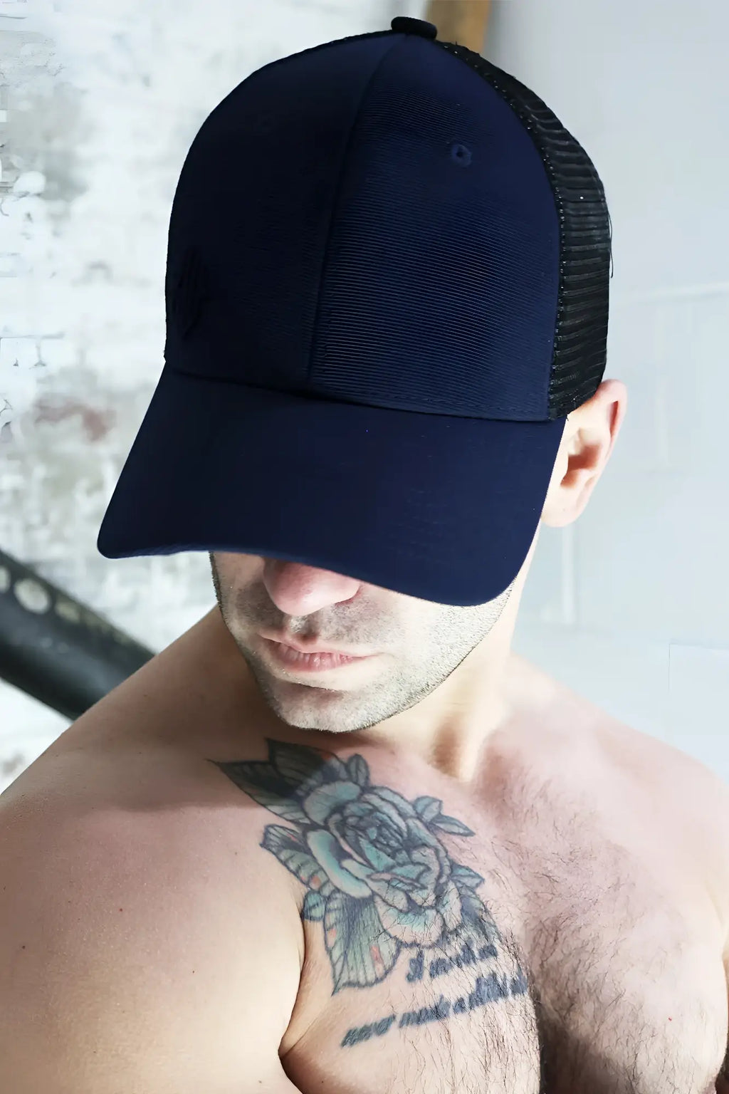 Dark navy blue dirty trucker hat with black mesh back and adjustable strap showing the back side of the cap