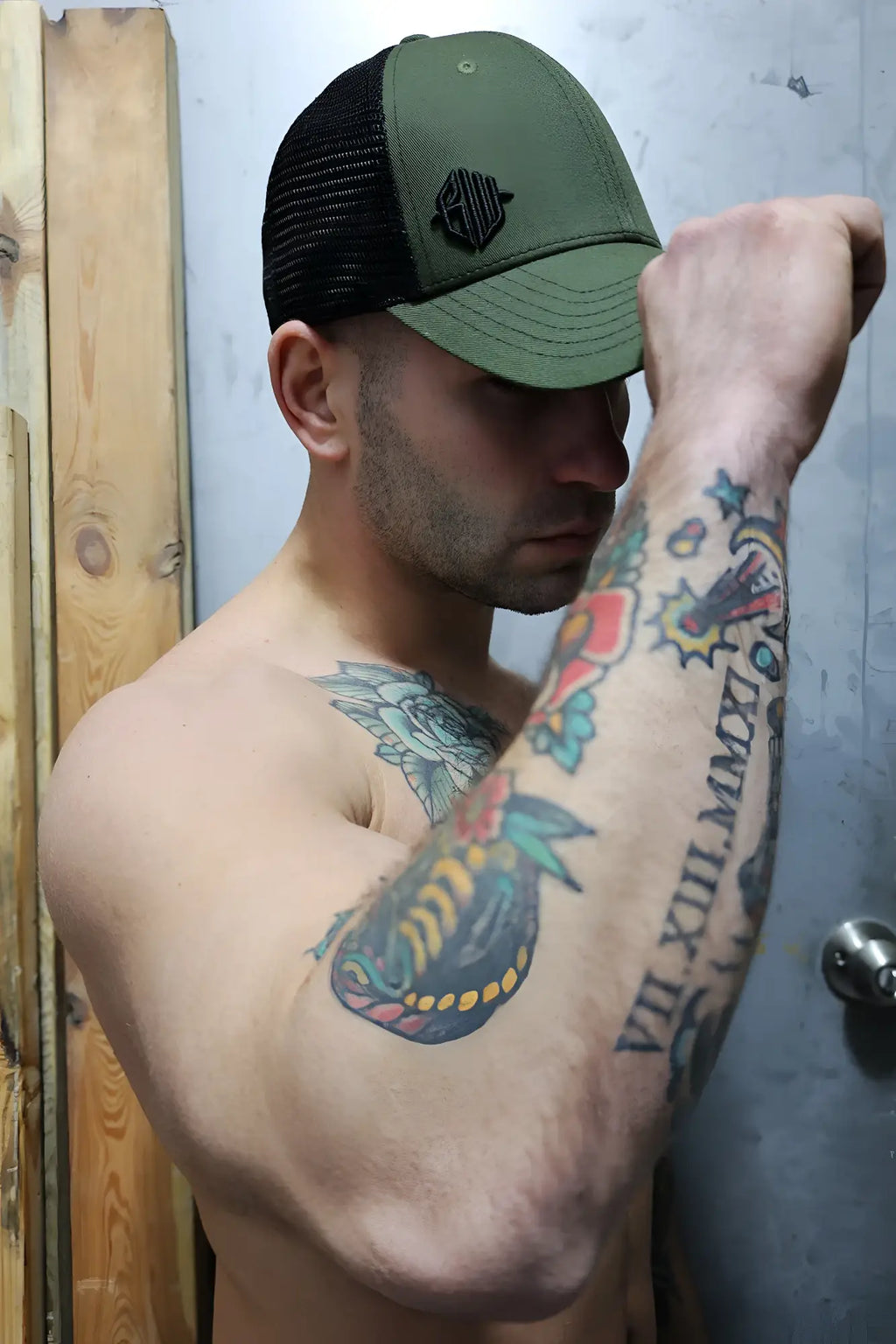 Olive green and black dirty trucker hat with embroidered logo on front panel for casual wear