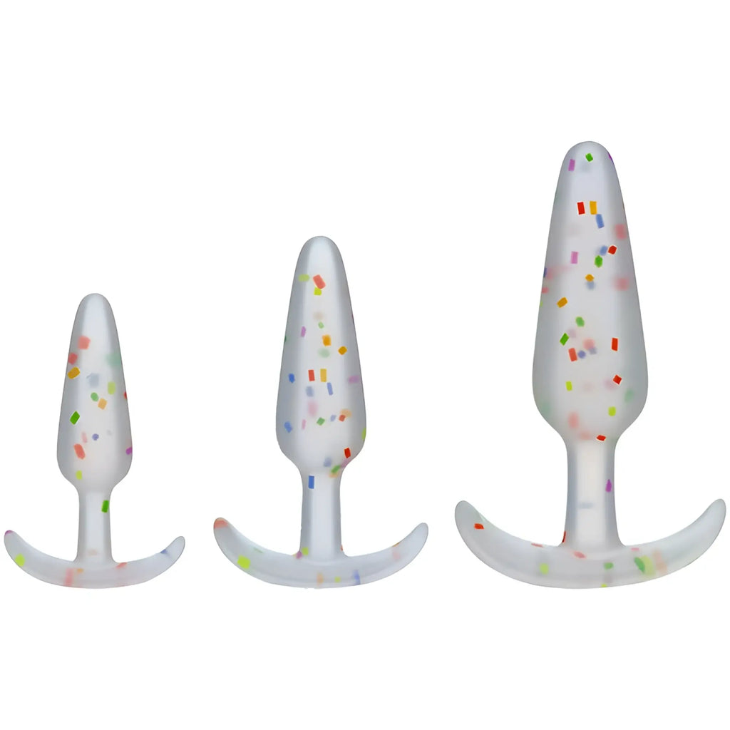 Set of three white silicone butt plugs with colorful confetti speckles and curved bases from doc johnson pride anal trainer set