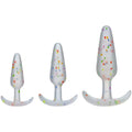 Set of three white silicone butt plugs with colorful confetti speckles and curved bases from doc johnson pride anal trainer set