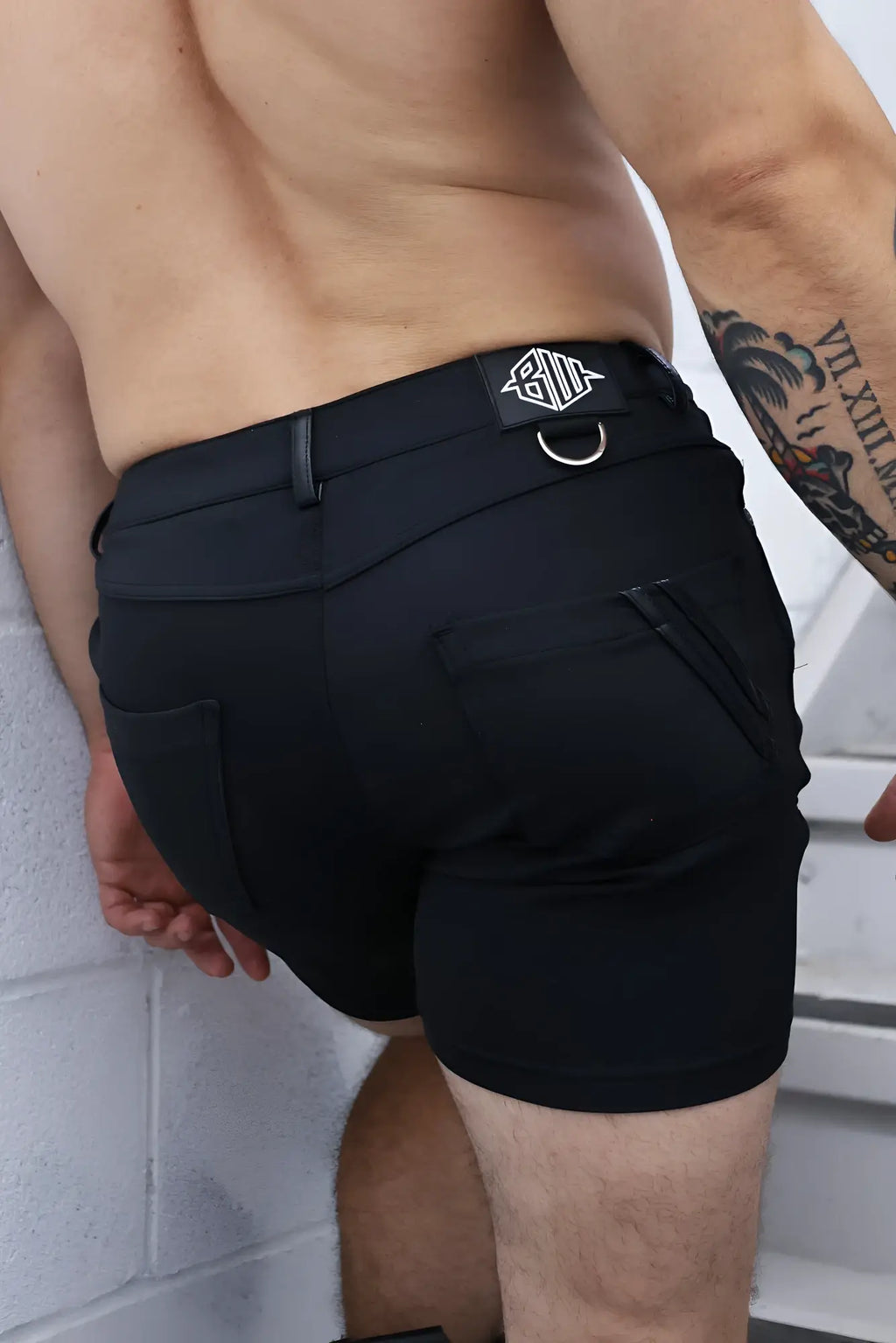 Black down low shorts featuring sleek modern design and branded patch on waistband for athletic use