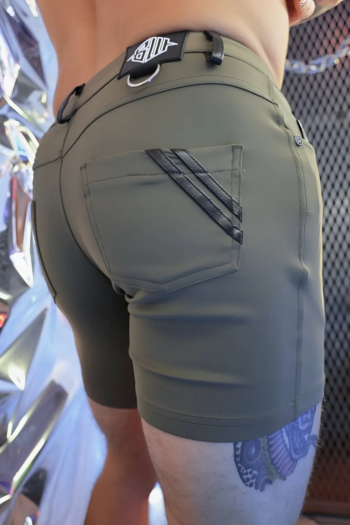 Olive green down low shorts back side showing black diagonal stitching on pocket and branded patch at waistband