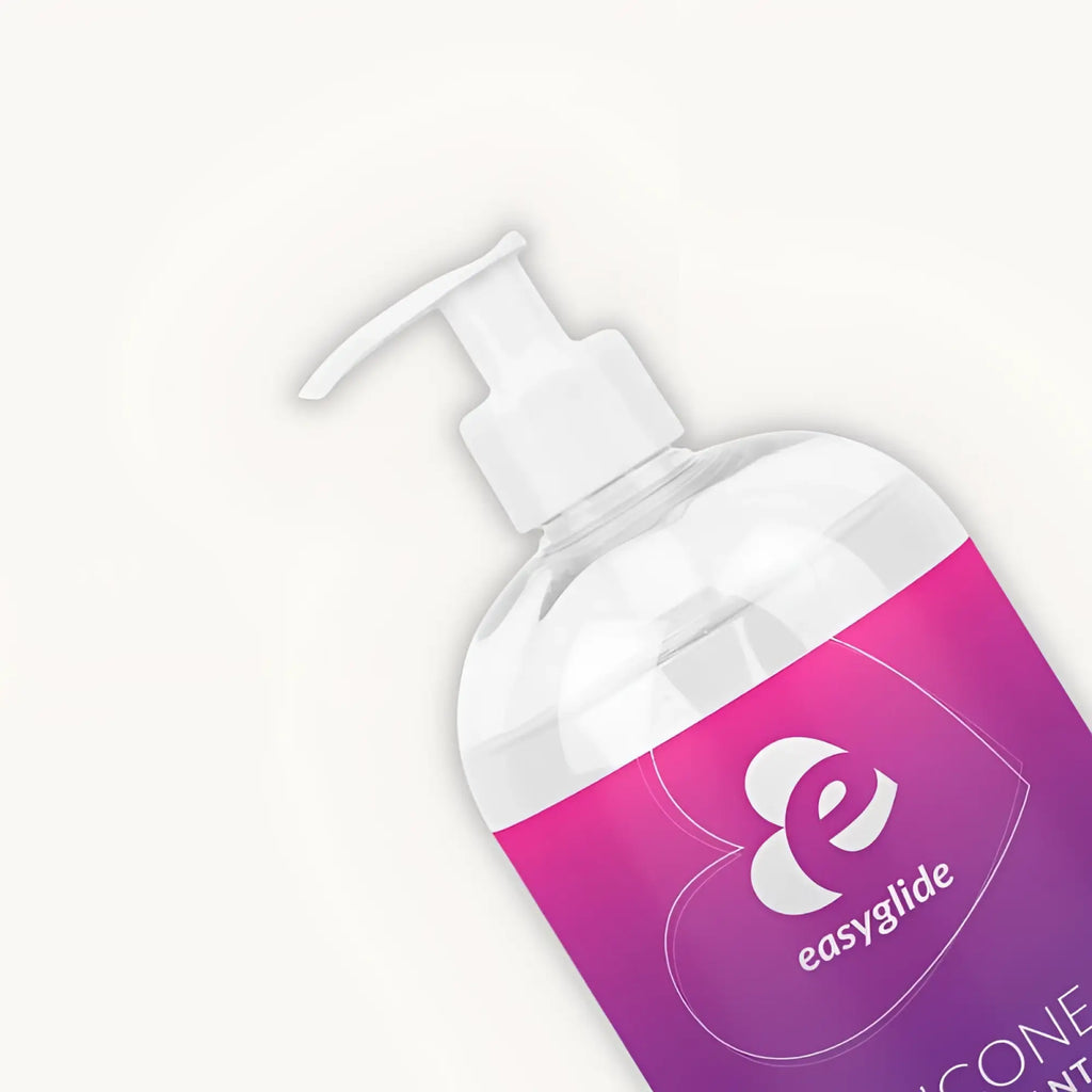 A clear plastic bottle with a white pump and pink to purple easyglide label containing silicone lubricant 1kg