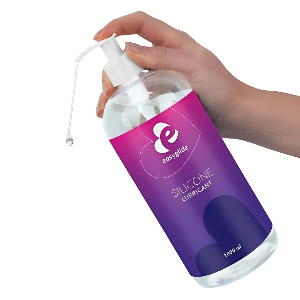 A clear plastic bottle with white pump of EasyGlide silicone lubricant 1kg featuring purple and pink label
