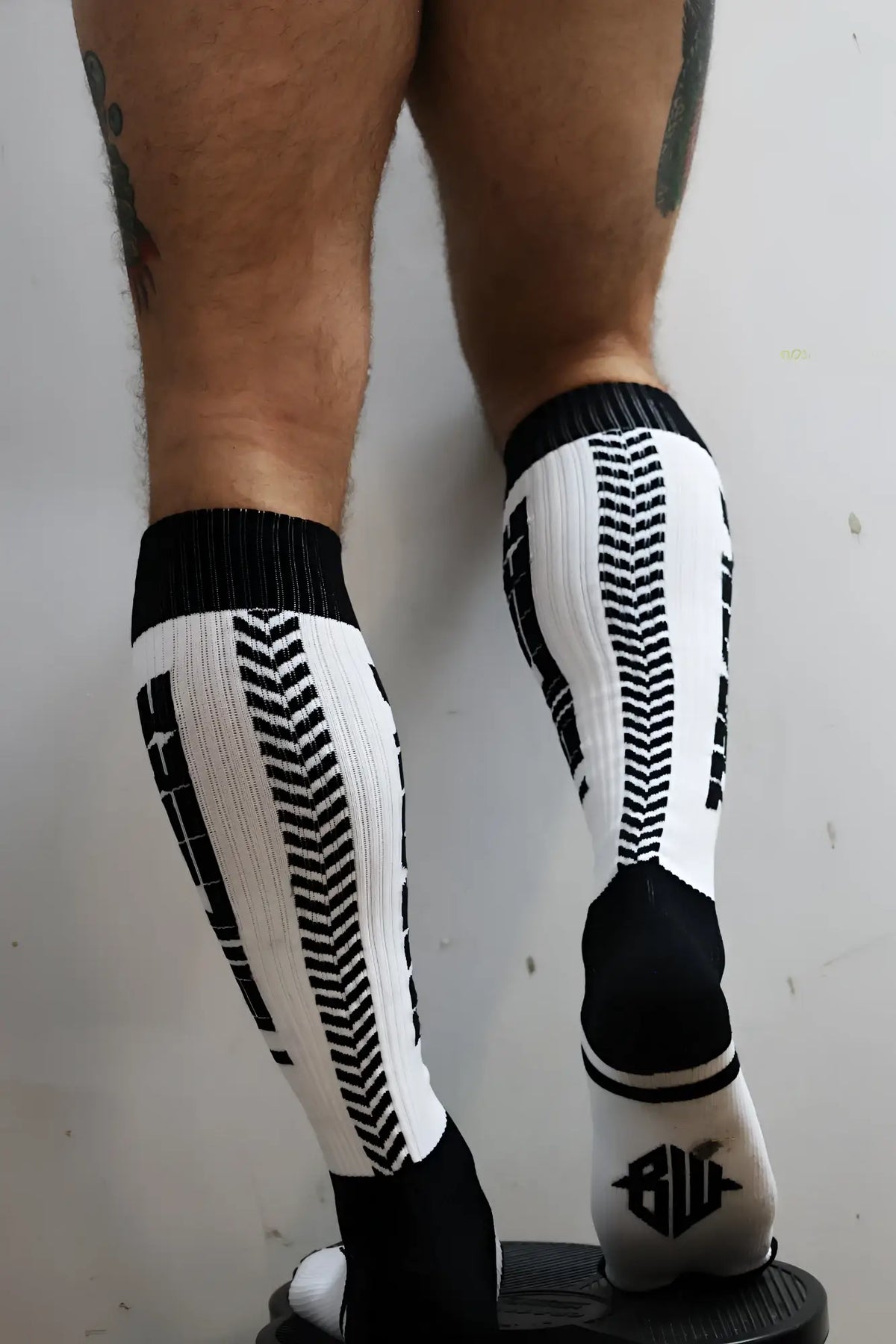 Black and white eternity knee-high athletic socks with bold tire tread pattern for enhanced grip and style