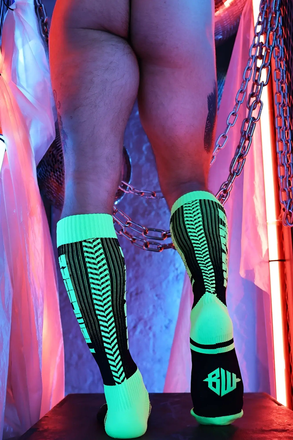Back view of eternity socks neon green and black athletic socks with chevron pattern and bw logo on heel