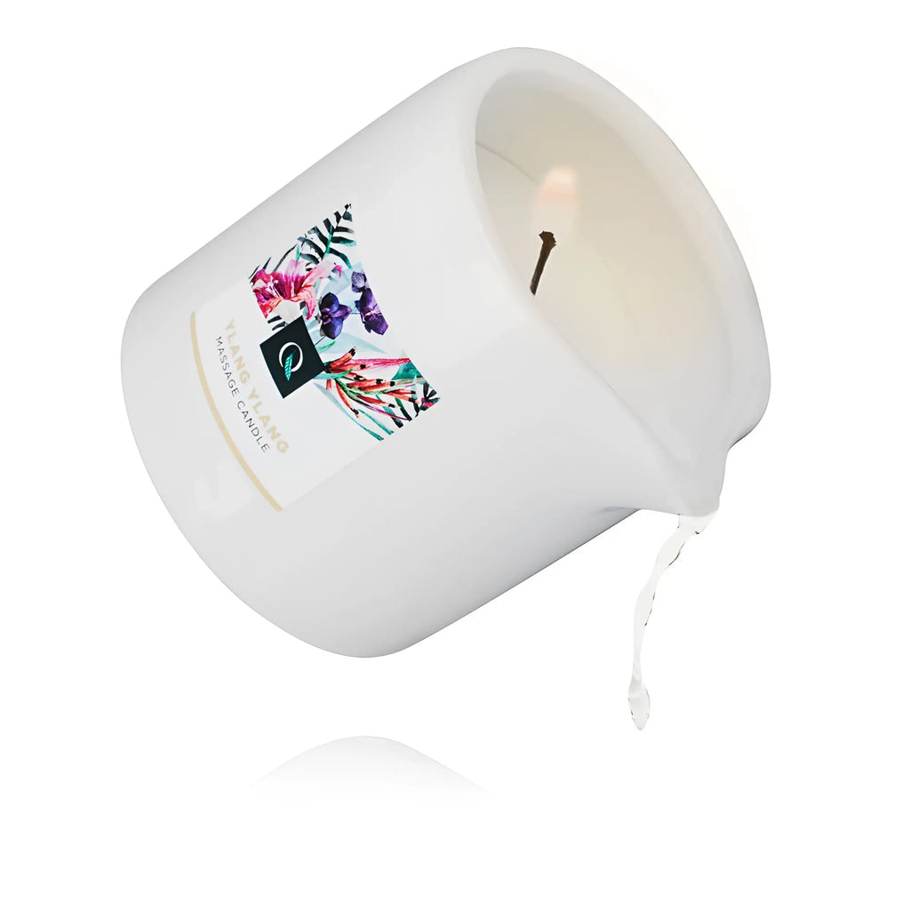 White ceramic exotiq massage candle ylang ylang with floral label and single wick melting slightly at the edge