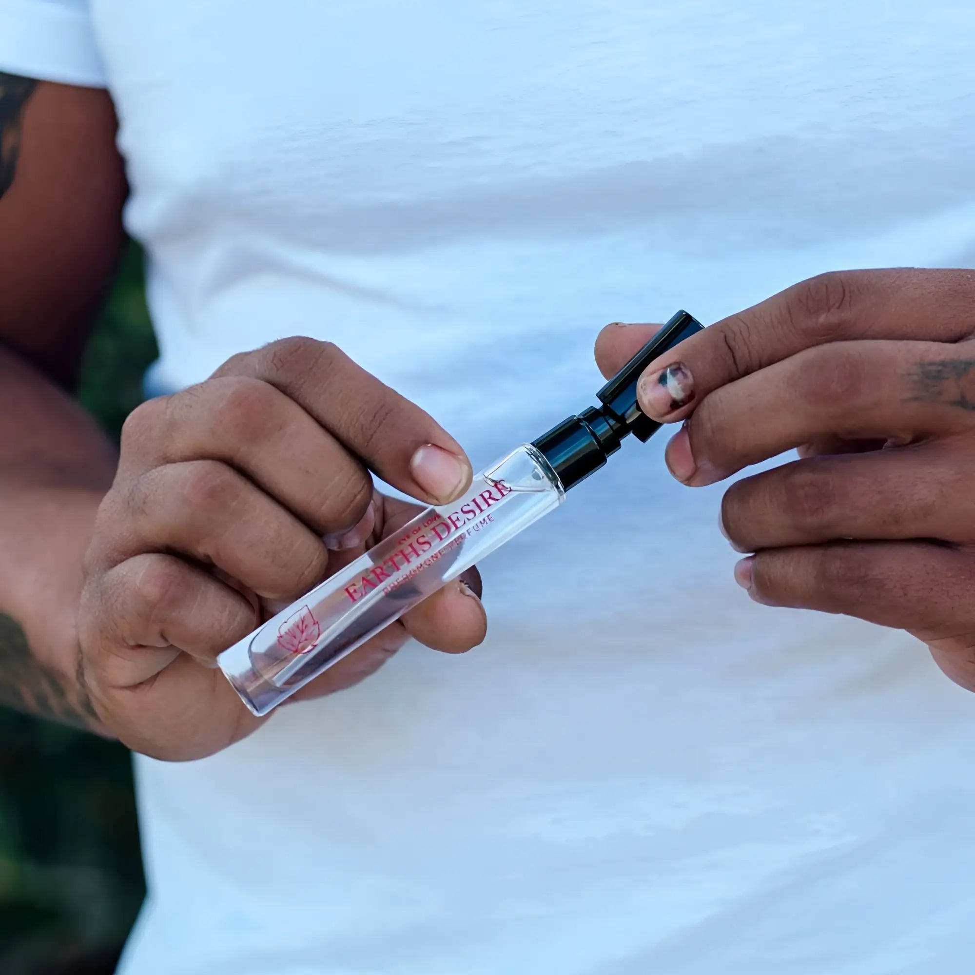 Clear glass travel spray bottle with black cap and red earths desire branding for eye of love bloom pheromone body spray 10ml