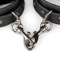 Black leather bondage cuffs from fetish collection with silver metal clasps and rivets for secure restraint