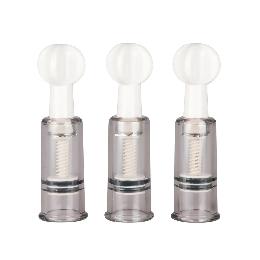 Three transparent plastic fetish collection nipple and clit suckers with white spherical tops and internal springs