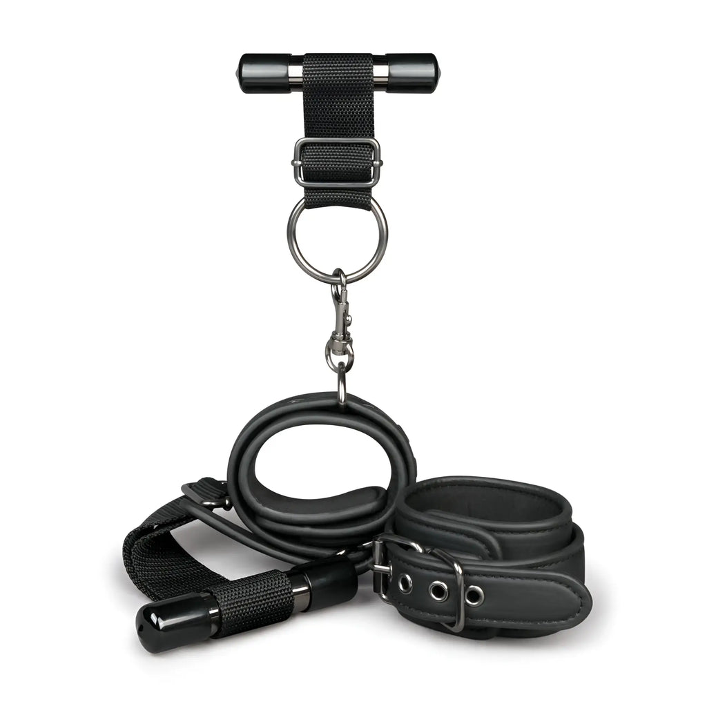 Black leather bondage set with metal hardware and t-bar harness from fetish collection over the door wrist cuffs