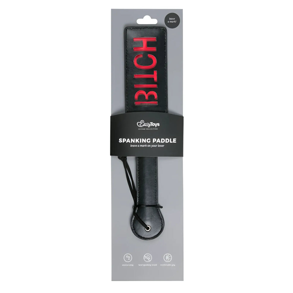Black leather spanking paddle from fetish collection with bold red bitch lettering on the handle