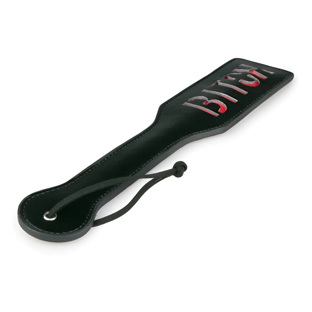 Black leather fetish collection paddle with the word bitch in red and silver lettering for adult use
