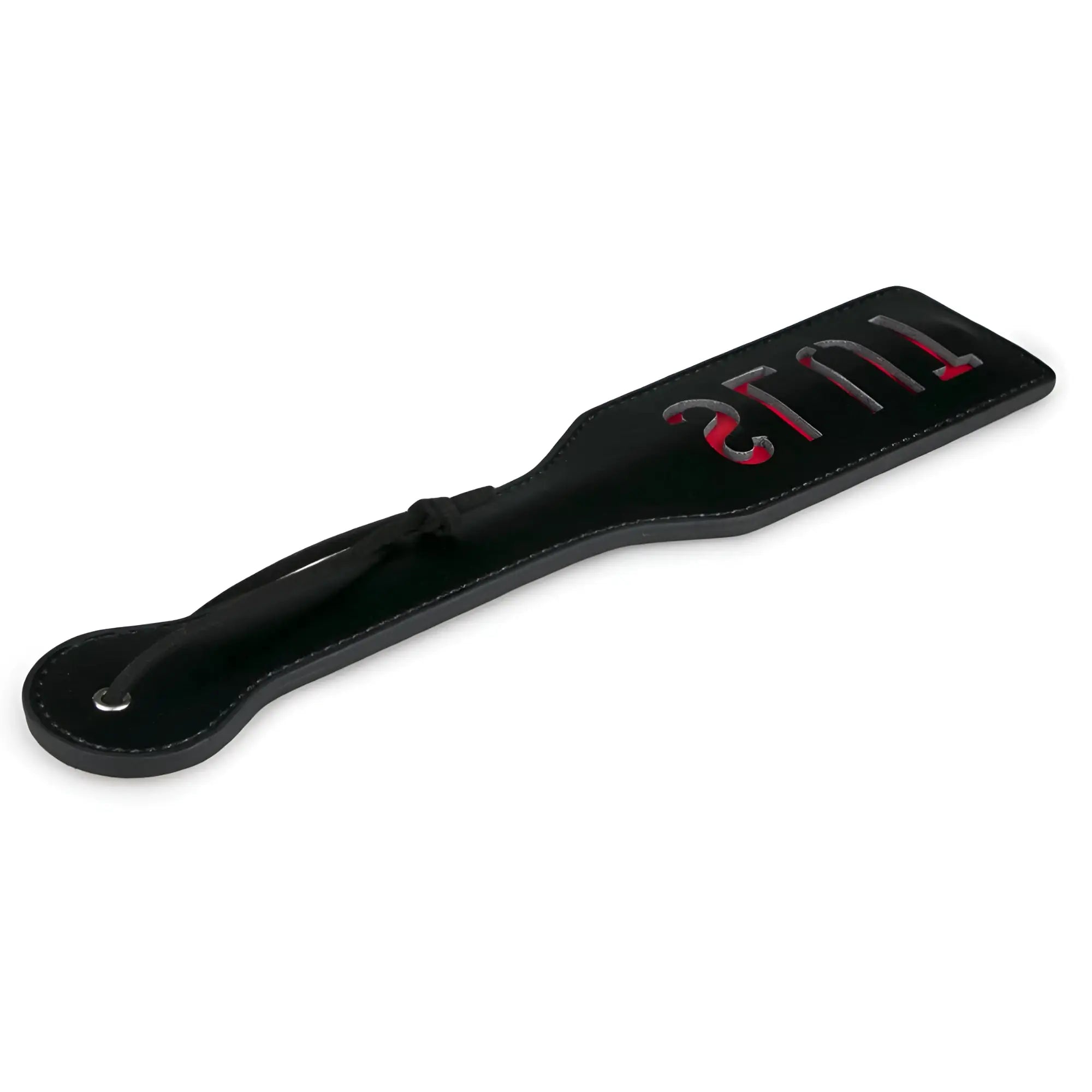 Black leather fetish collection paddle slut with red and silver lettering reading tulis on flat surface