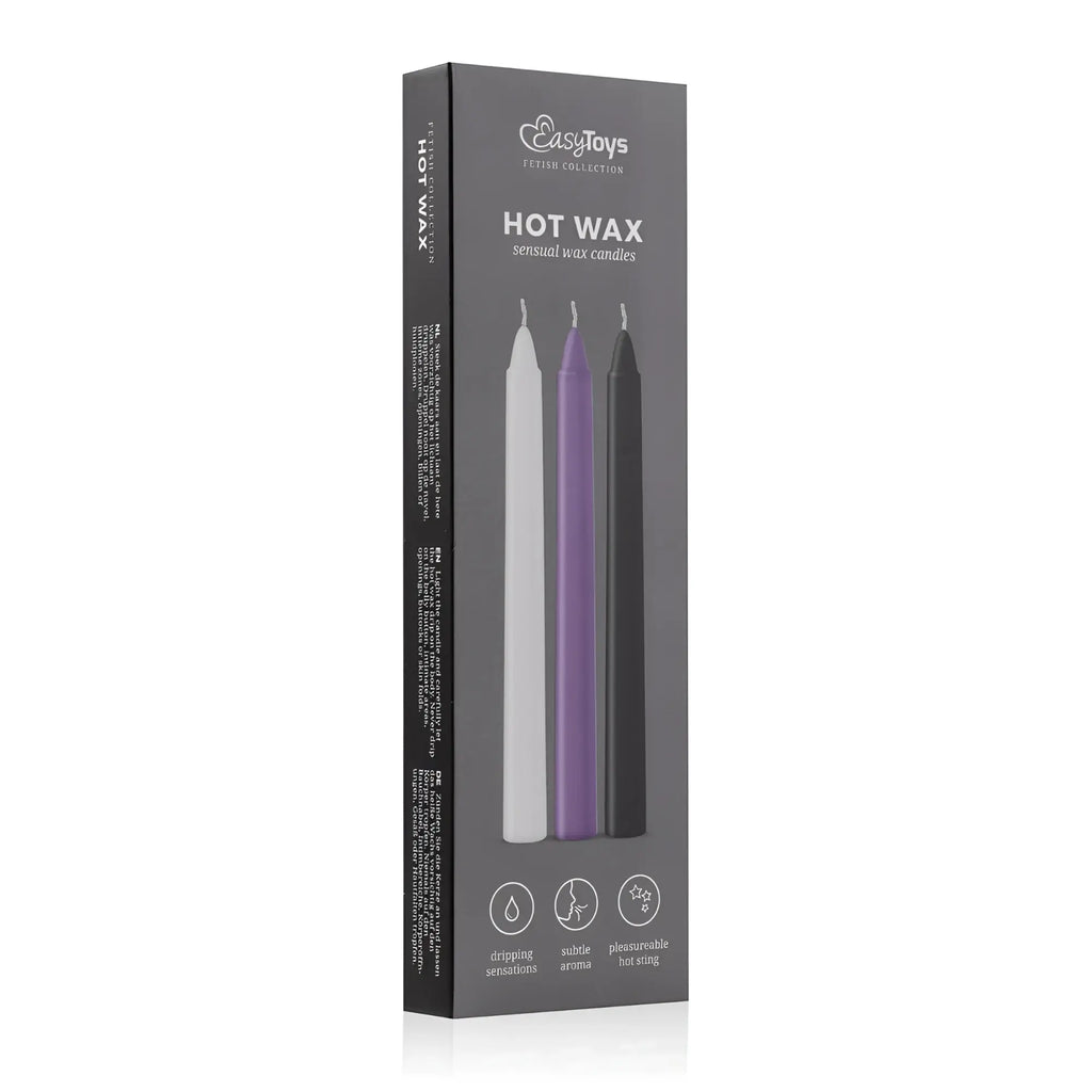 A sleek black box containing three slender sensual hot wax candles in white purple and black from fetish collection