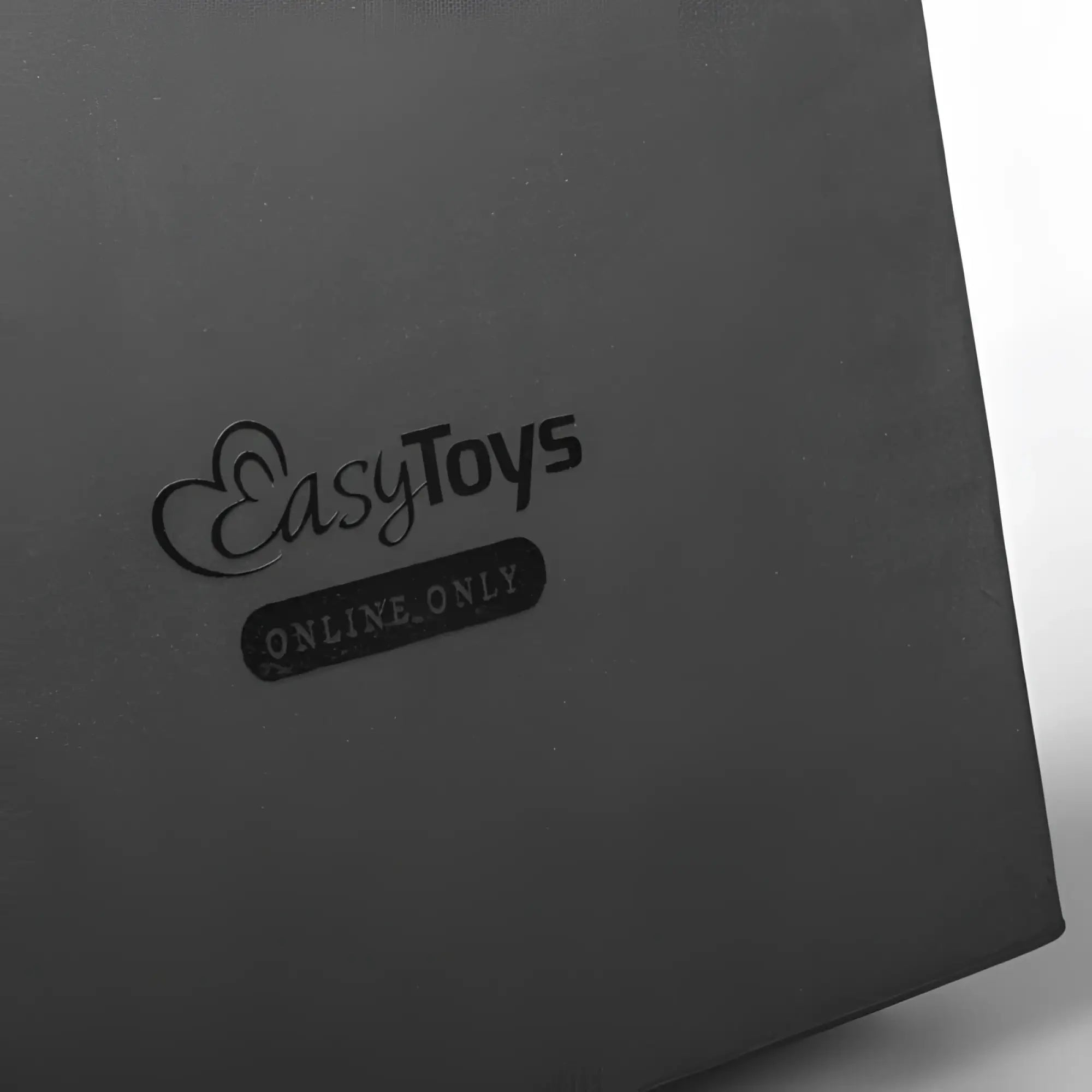 Black matte cardboard box with embossed easytoys logo and online only tag for fetish collection silicone realistic strap-on