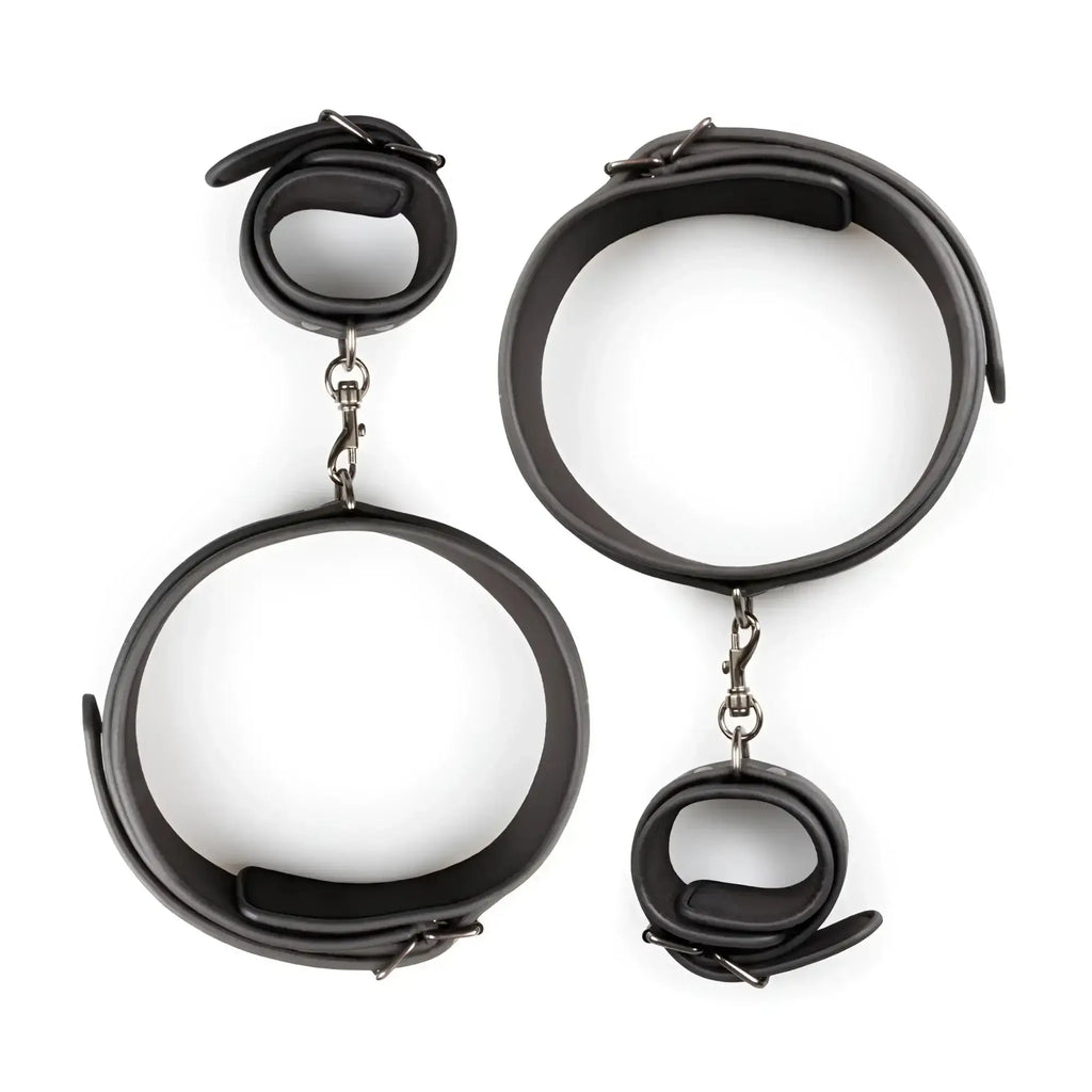 Fetish collection thigh and wrist cuff set featuring black leather handcuffs with silver-toned metal clasps