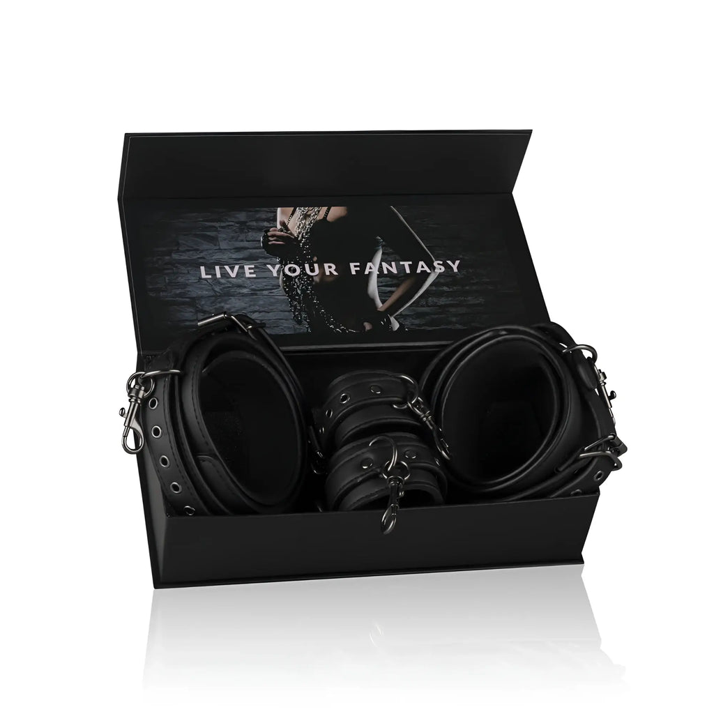 Black leather thigh and wrist cuff set with metal hardware in a sleek black box from fetish collection