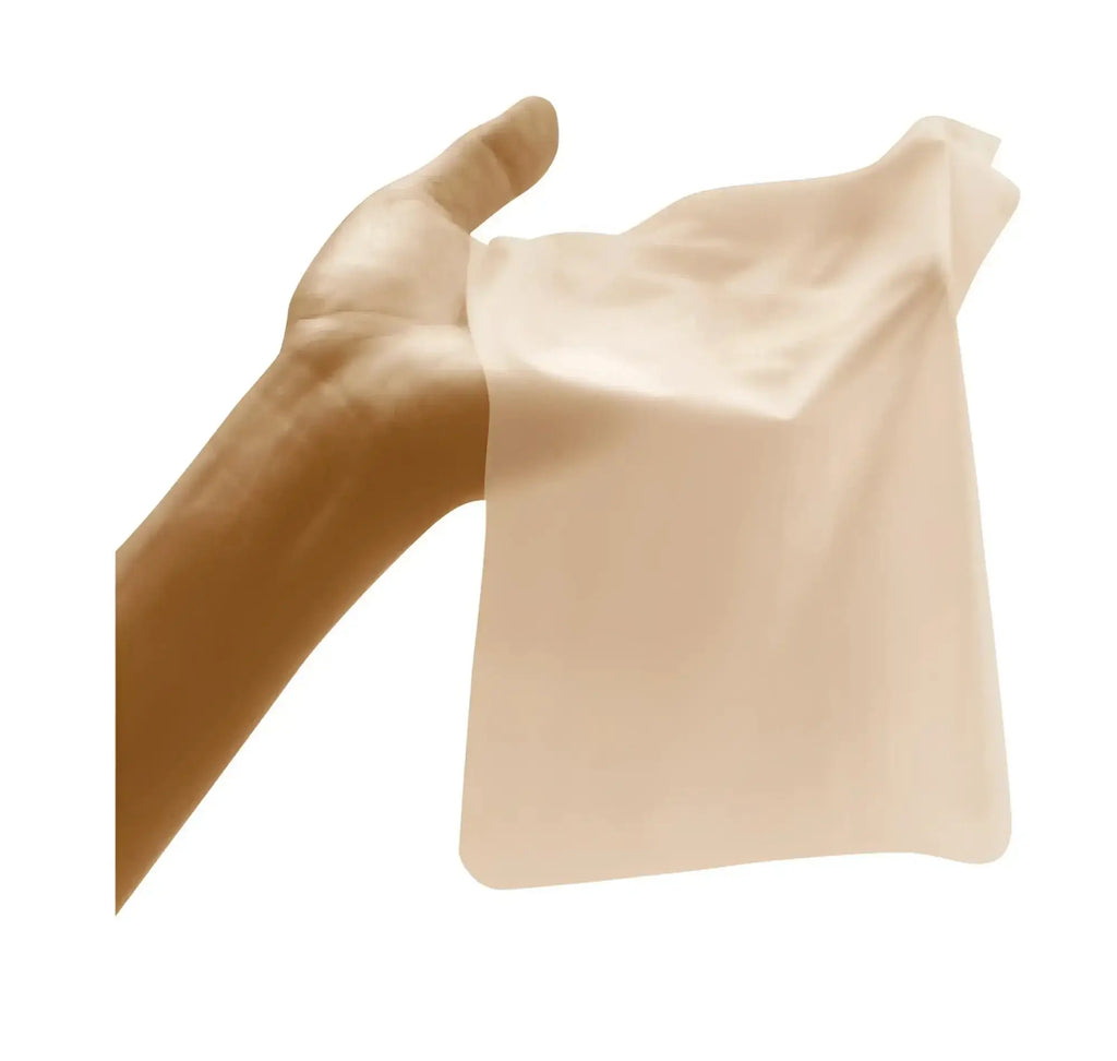 A translucent beige silicone sheet from four seasons sheer dams 100 pc mixed box held gently in a hand