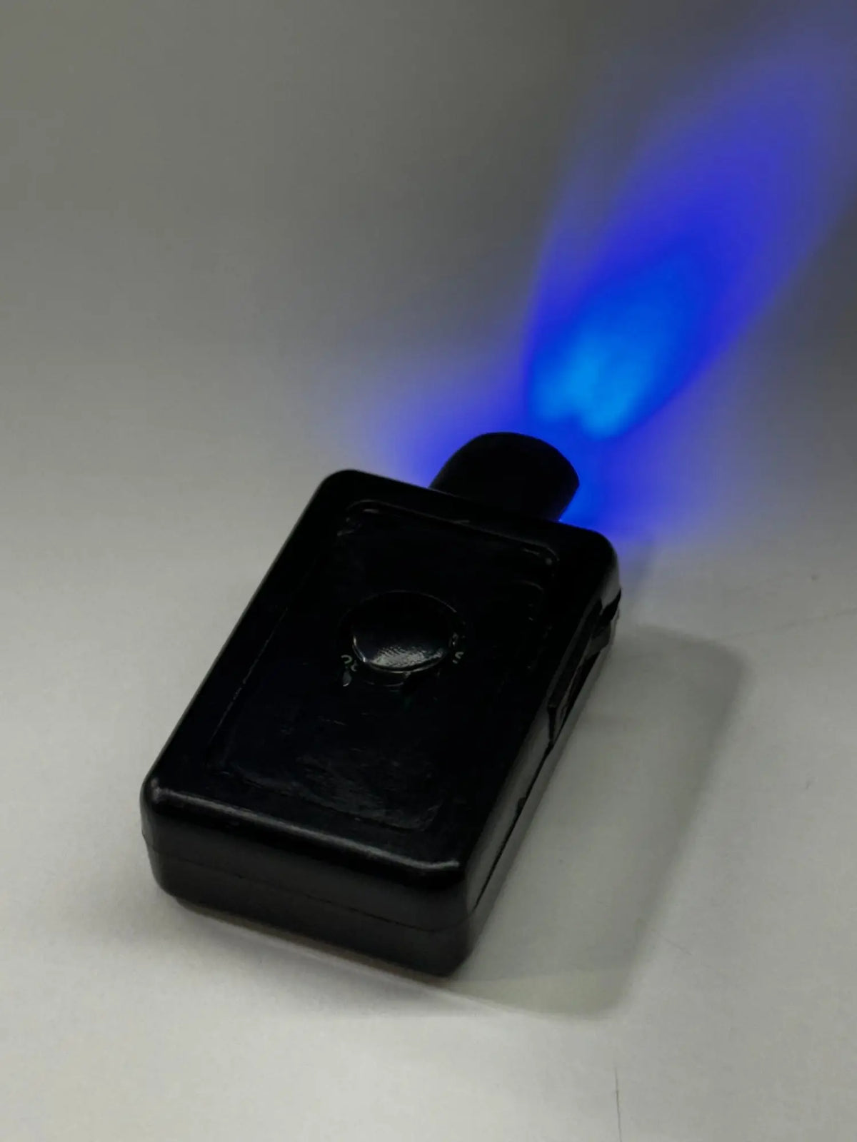 Black rectangular uv light pen emitting bright blue glow for garrison hat battery use