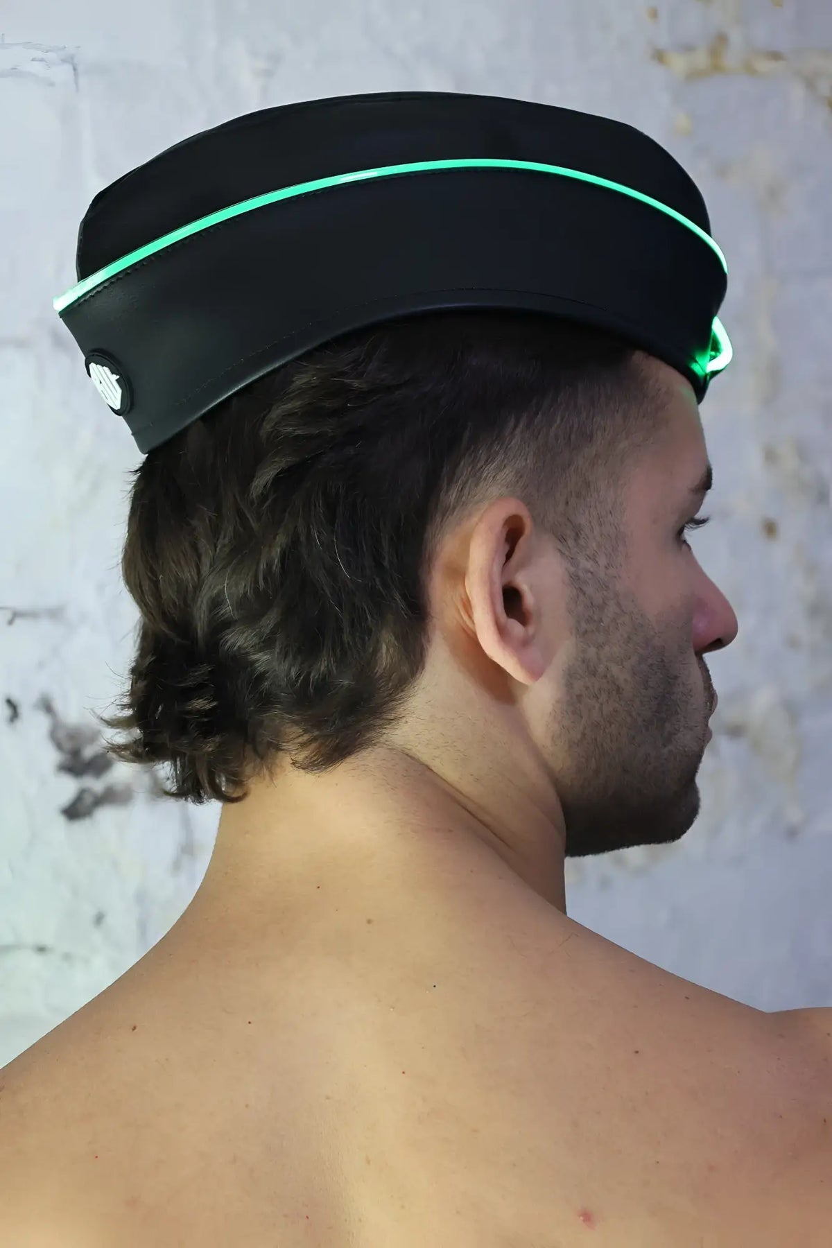 Black garrison hat featuring glowing green trim and a small circular emblem on the side