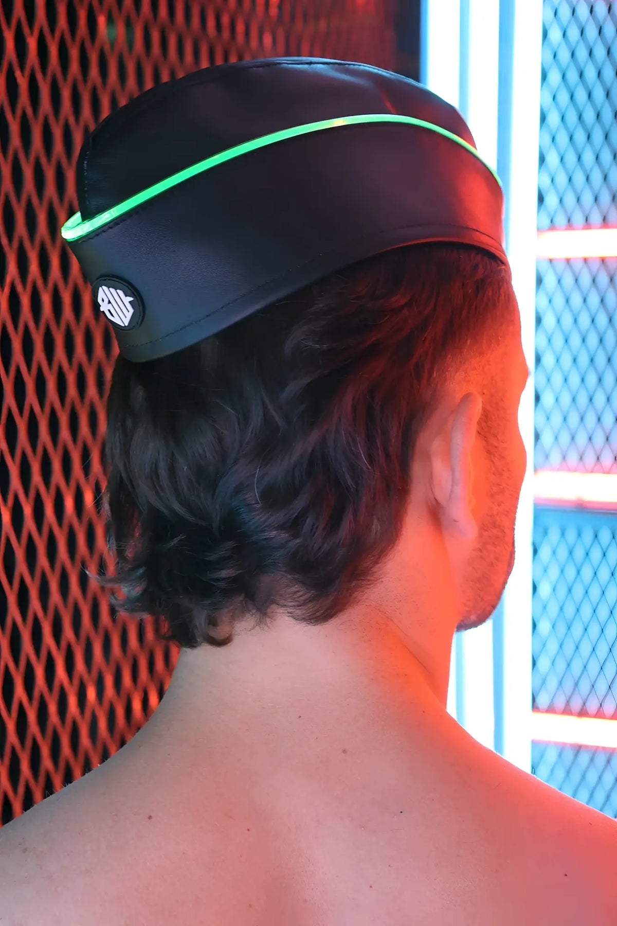 Black leather garrison hat with glowing green trim and circular logo on the side