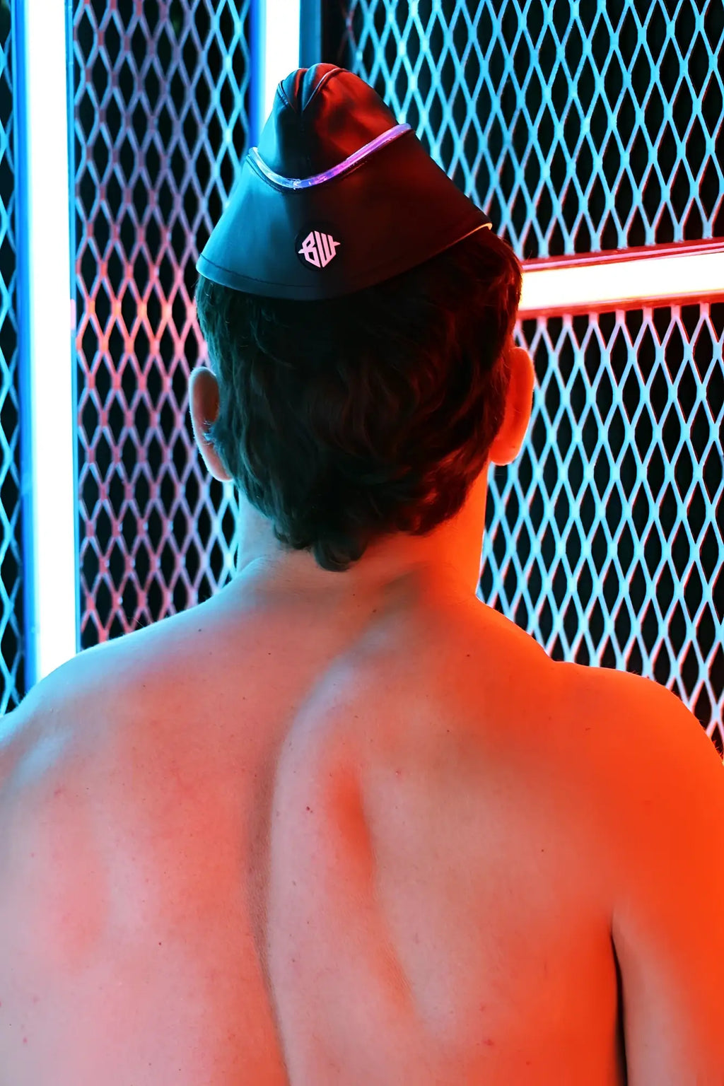 Black leather garrison hat with purple trim and white logo on the front
