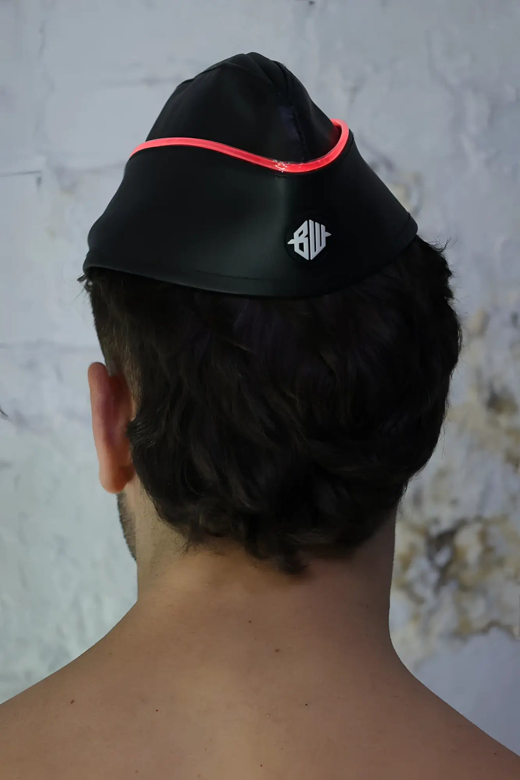 Black swim cap garrison hat with bright pink neon trim and white logo on the side for swimming use