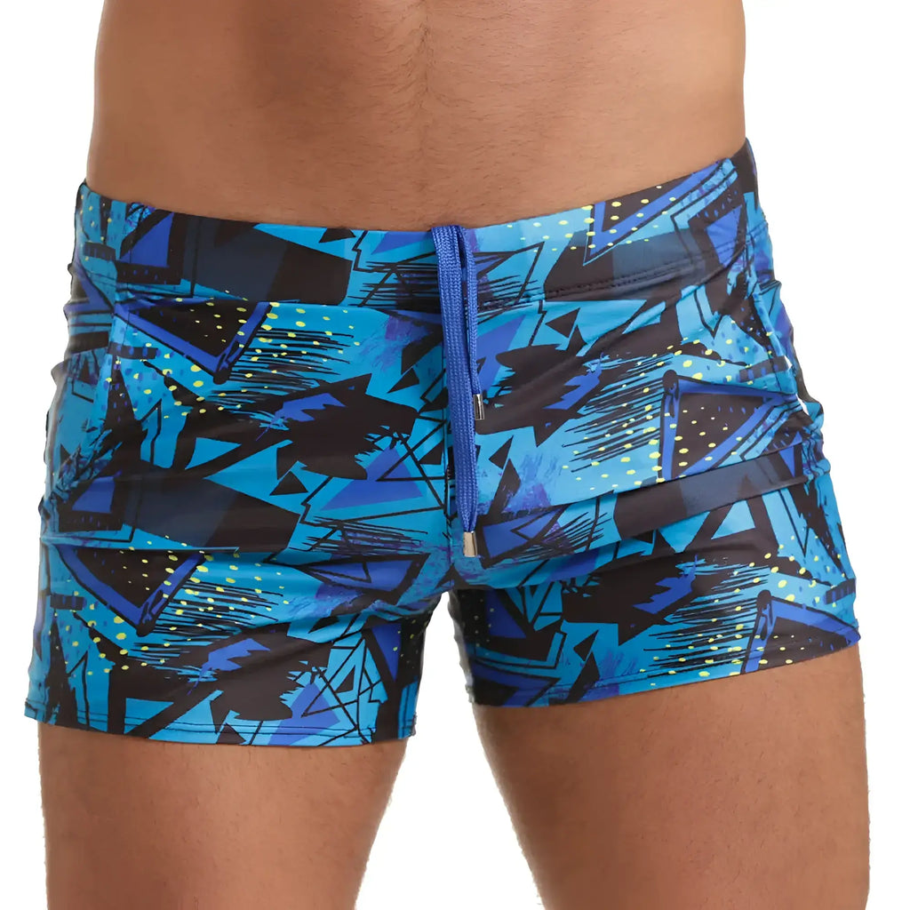 Blue and black geometric-patterned swim trunks with matching blue zipper from gigo abstract beachwear collection
