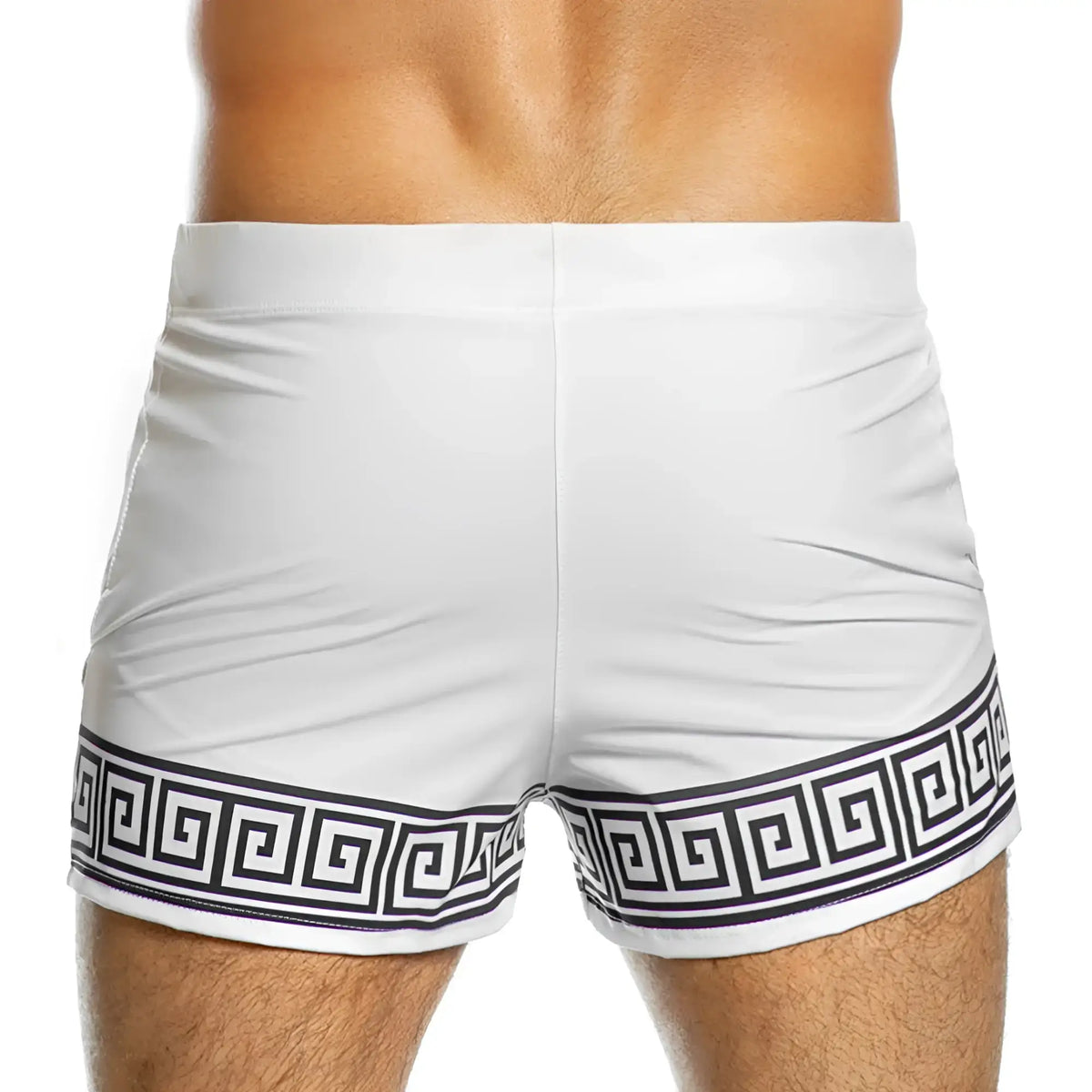 White swim trunks from gigo arabesque beachwear featuring a bold black greek key pattern along the hem