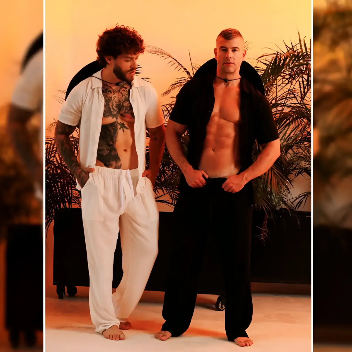 Two men standing side by side with one wearing a gigo chalis black short-sleeved shirt open over dark trousers