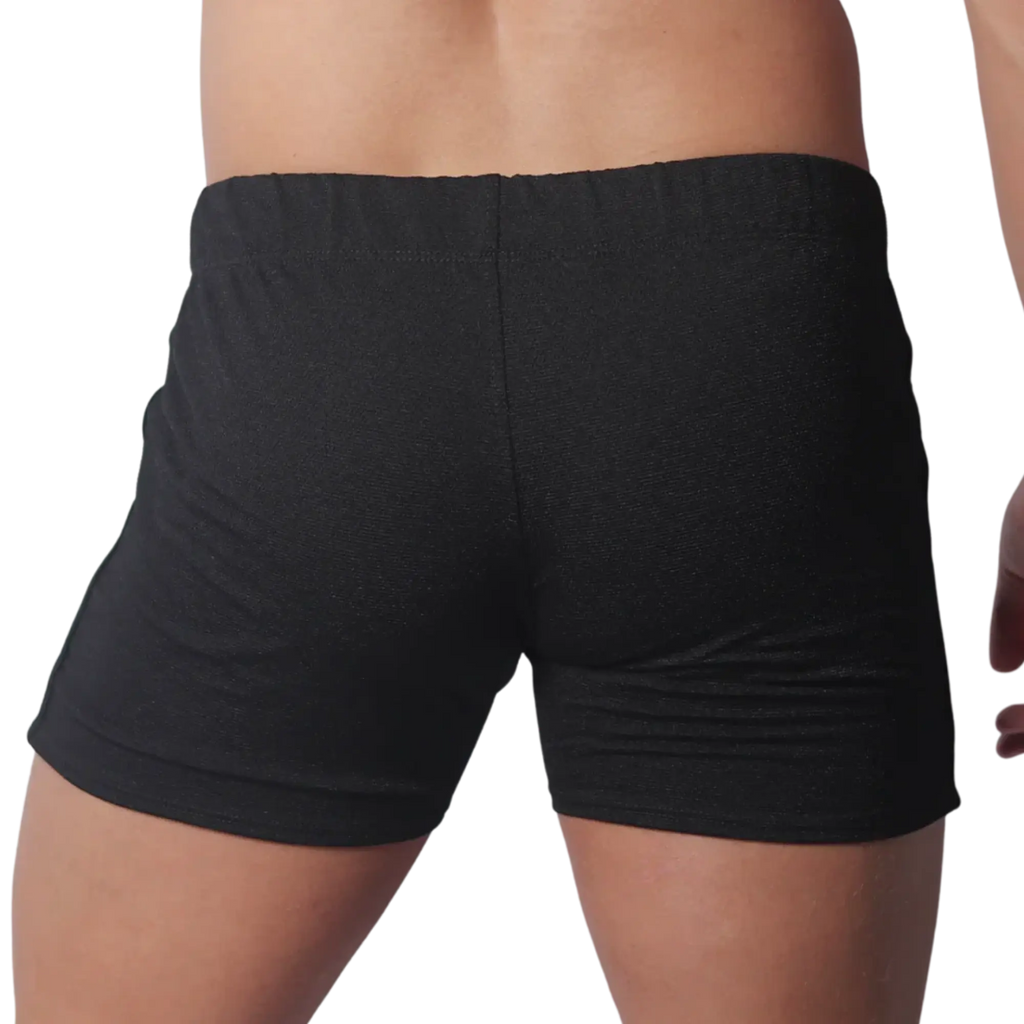 Back view of black form-fitting athletic shorts with a textured fabric and elastic waistband.