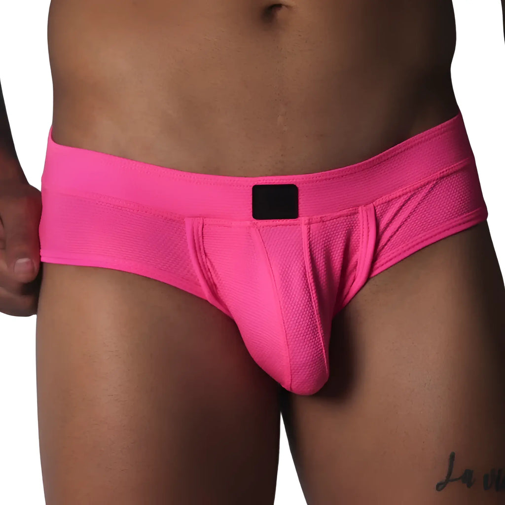 Fuchsia-coloured low-rise briefs in textured mesh fabric with a centered black logo patch on the waistband.