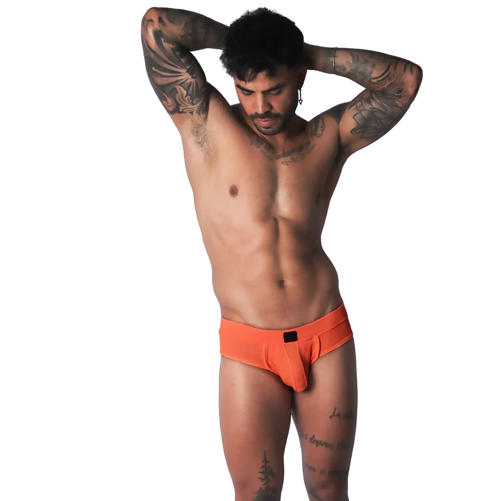 Bright orange low-rise brief in a textured, breathable fabric with a small black center-front logo patch.