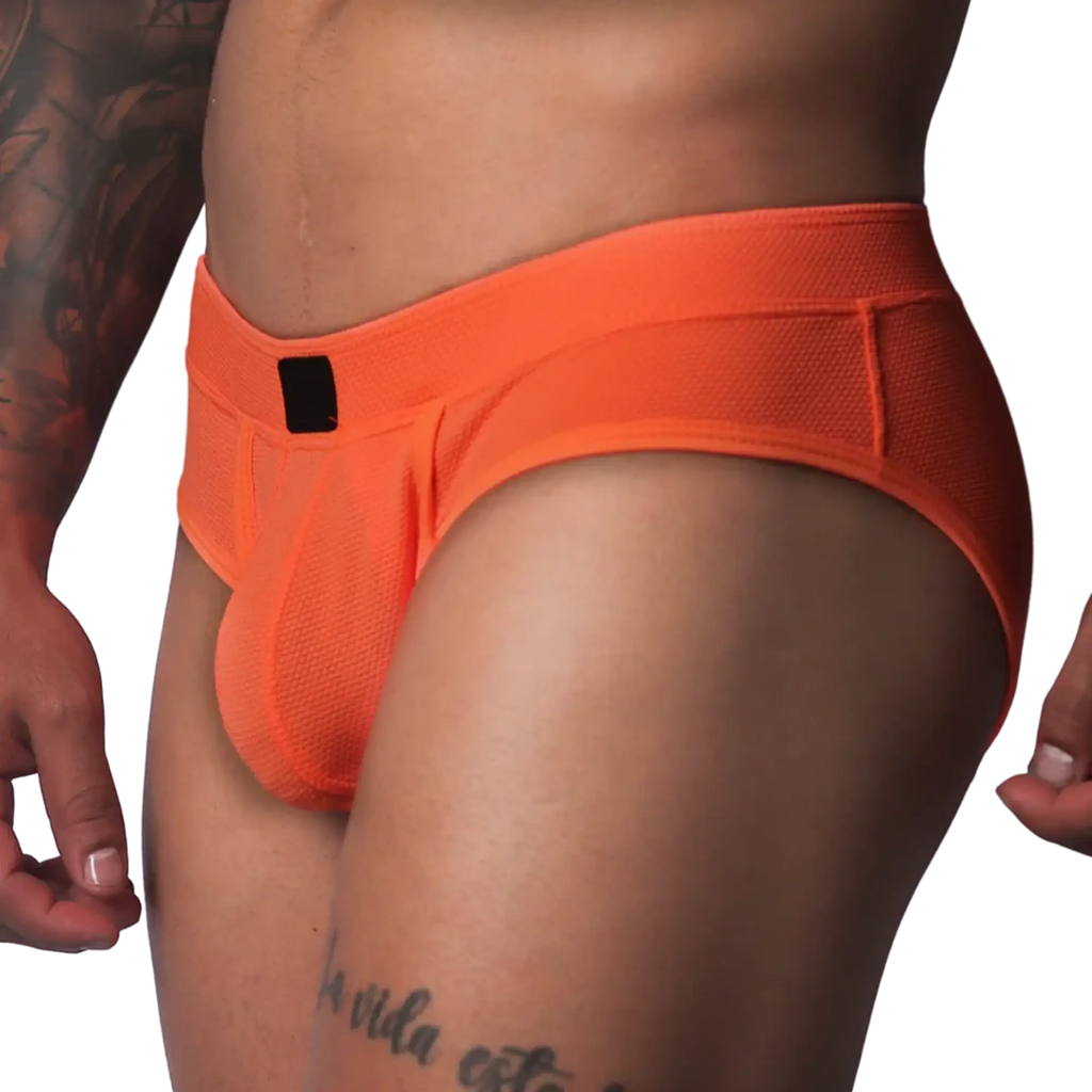 Bright orange textured mesh athletic brief with a wide waistband and a small black rectangular logo patch in front.